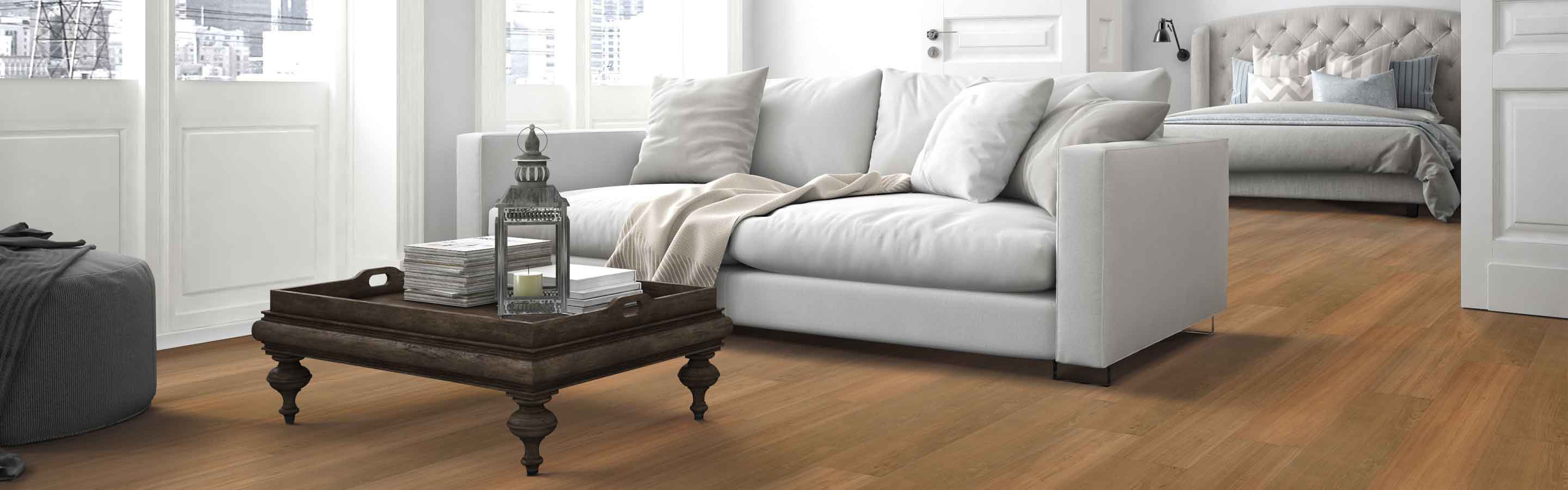 honey hued wood look vinyl plank in open concept modern living room with double doors to bedroom